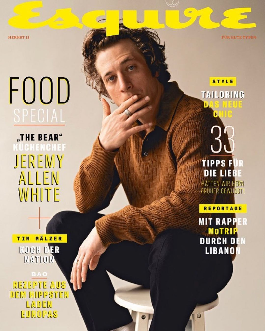 Esquire magazine cover featuring actor Jeremy Allen White wearing a brown collared shirt and black pants, seated against a beige backdrop.