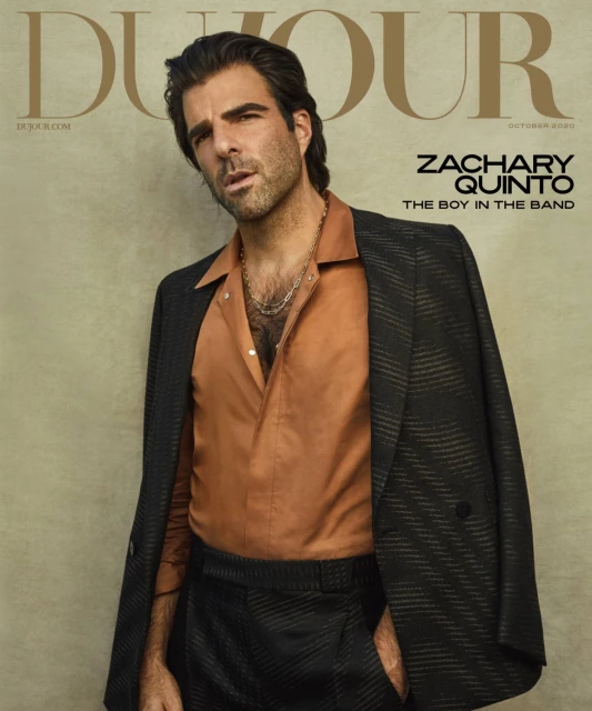 Magazine cover featuring Zachary Quinto in a brown shirt and patterned blazer, styled with a silver chain, against a neutral backdrop.
