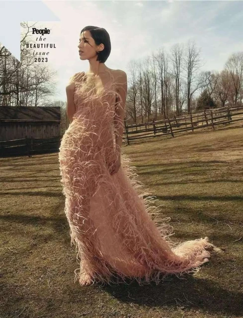 Cover of People's The Beautiful Issue 2023 features a woman in a pink feather dress in a rural setting, with a barn and meadow.