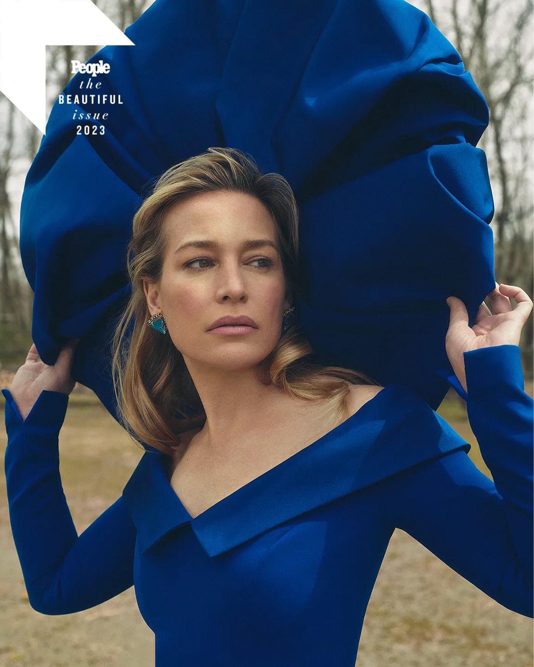 Portrait of Robin Wright for People Magazine's The Beautiful Issue 2023, wearing a blue dress and turquoise earrings outdoors.