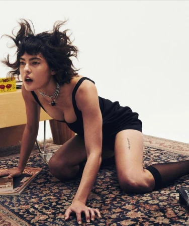 Woman in a black tank top and shorts on all fours on a patterned rug in Los Angeles shot by Jonny Marlow