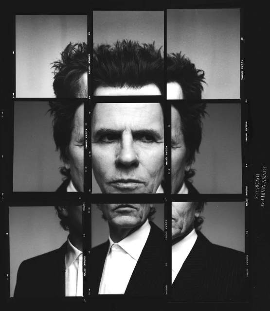 Black and white portrait of an adult man in a dark suit, created from multiple framed images arranged in a grid format.