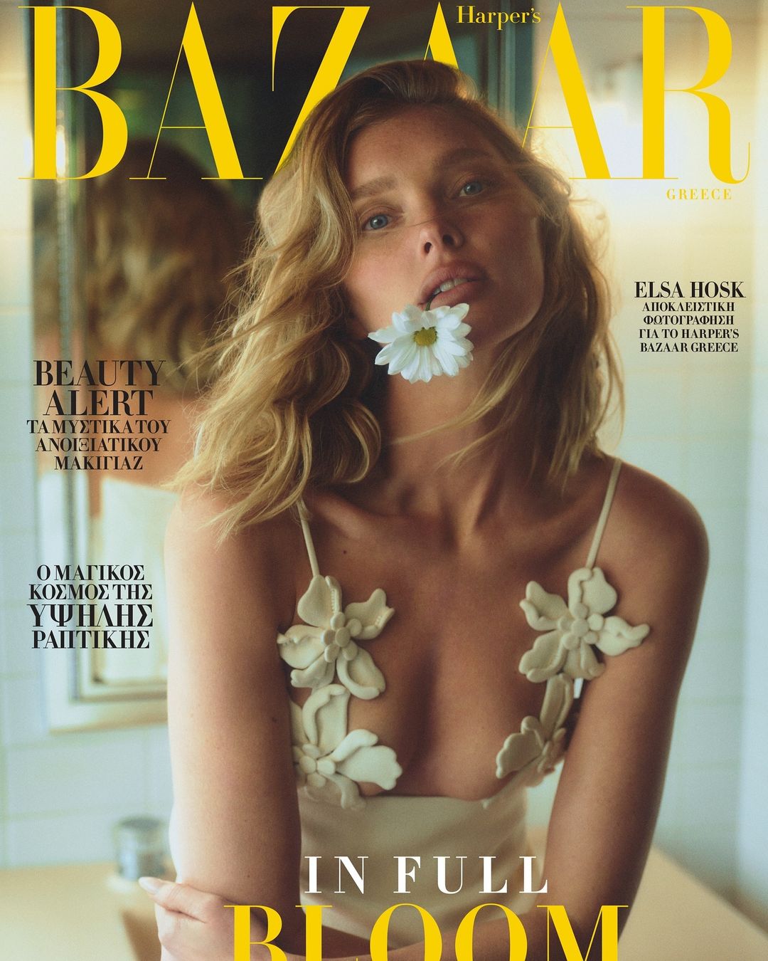 Harper's Bazaar Greece cover featuring Elsa Hosk with a white flower in her mouth, wearing a dress with floral accents.