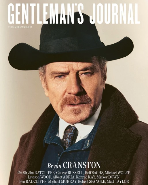 Magazine cover featuring Bryan Cranston in a black cowboy hat and brown coat, set against a neutral backdrop with magazine text overlay.