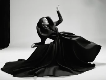 Jessica Alba wearing a voluminous black gown with a structured cowl collar in a dramatic studio portrait by Jonny Marlow