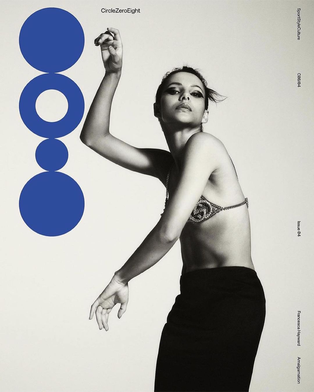 A monochrome fashion-style portrait features a woman in a bra top and skirt, with a geometric blue graphic to the side on an off-white background.