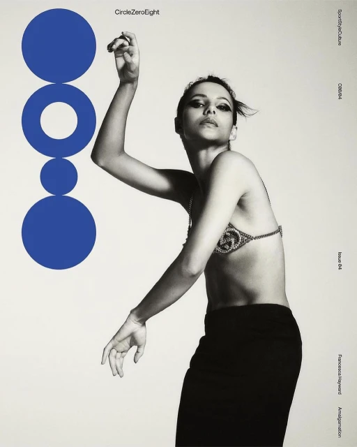 A monochrome fashion-style portrait features a woman in a bra top and skirt, with a geometric blue graphic to the side on an off-white background.
