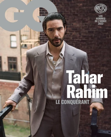 GQ magazine cover featuring Tahar Rahim in a suit on a balcony with a brick building backdrop, showcasing men's fashion and celebrity.