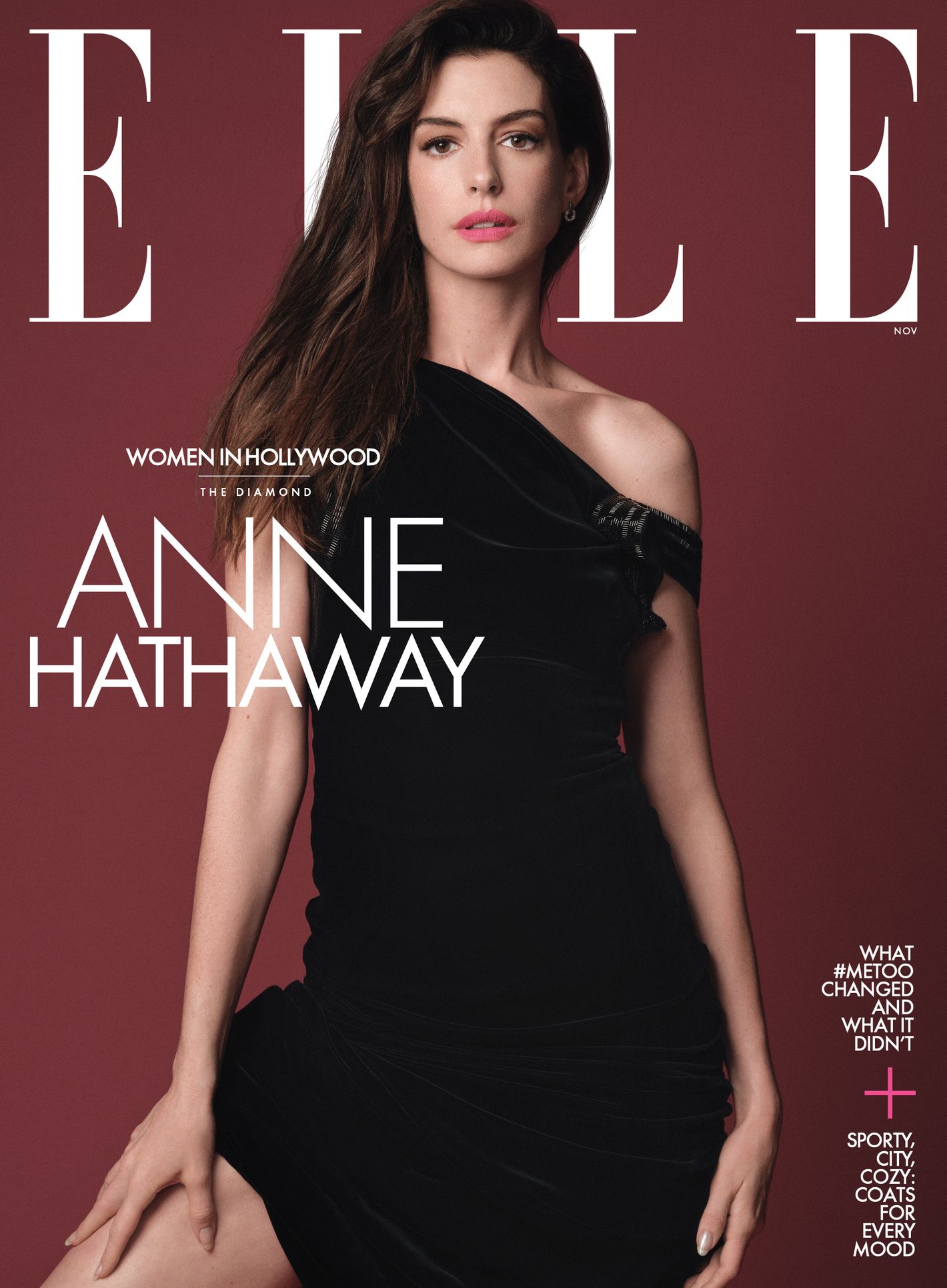 Anne Hathaway on Elle magazine cover; she poses in a black dress against a burgundy background with white text. Fashion and entertainment.