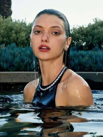 Close-up portrait of a woman submerged in water wearing a dark halter top with diamond embellishments by Sharif Hamza.