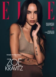 Zoe Kravitz in a beige crop top with dark hair and arm tattoos against a dark teal background for an Elle magazine cover portrait