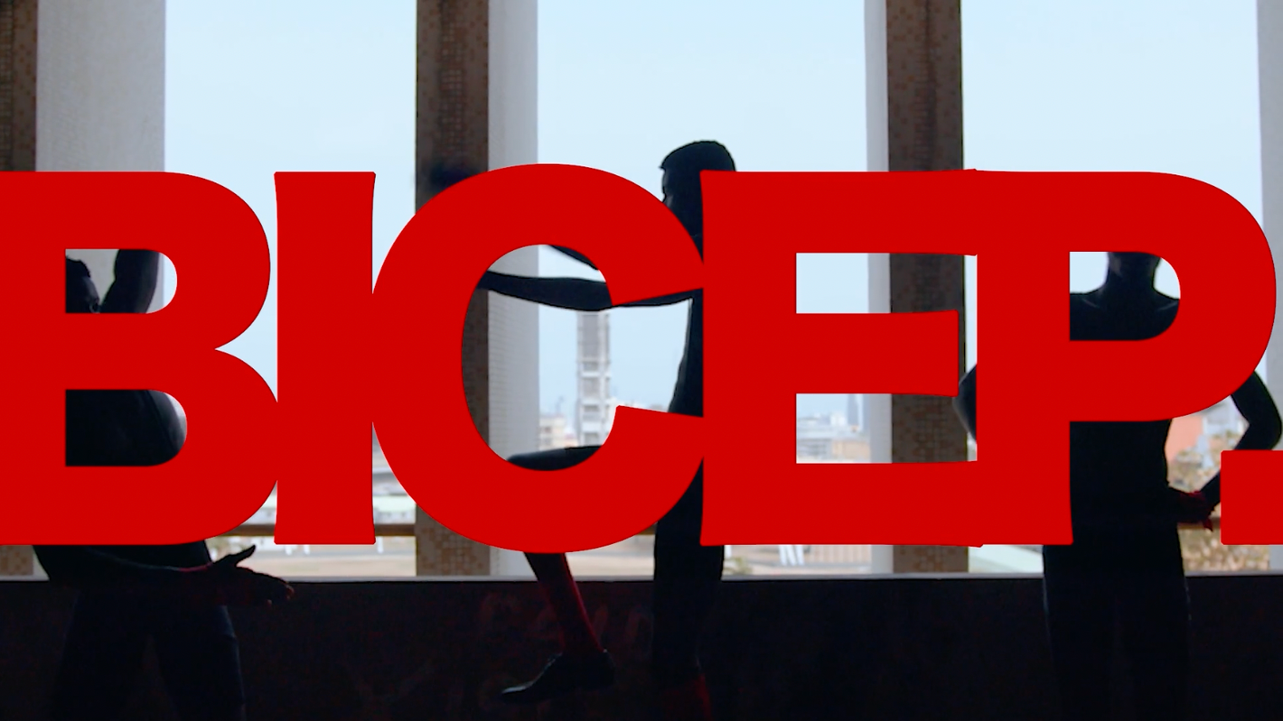 Silhouetted figures stand behind large, red 'BICEP' text against a window with a city view, creating an abstract composition.