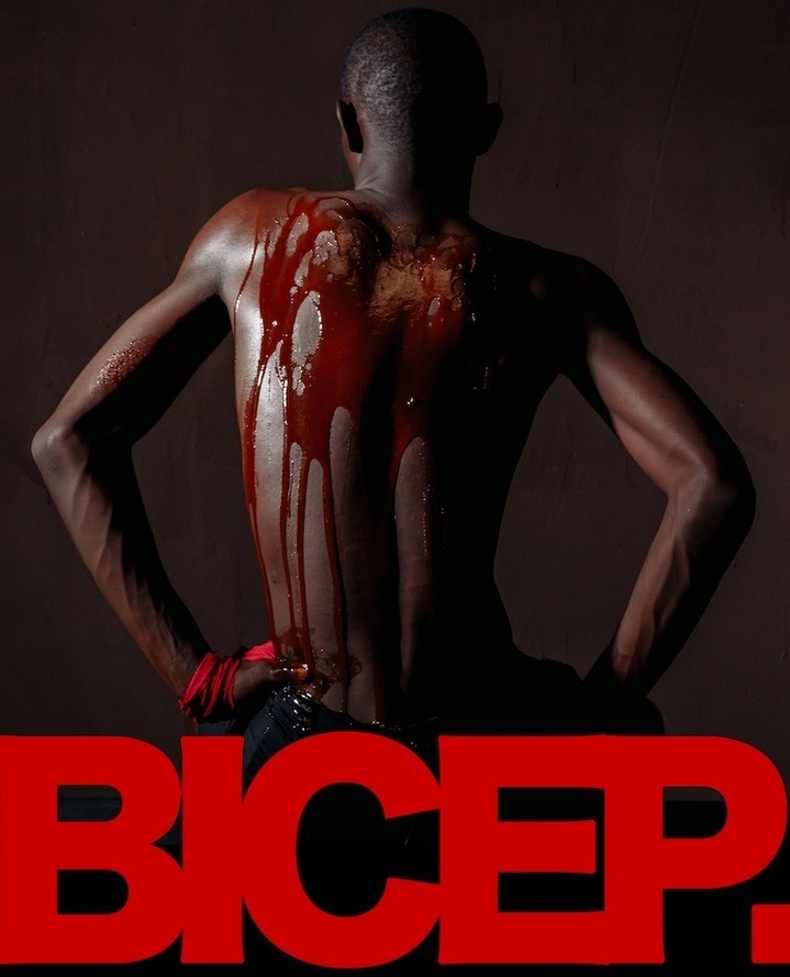 Artistic shot of an adult male with blood-like substance on his back, posing against a dark backdrop with red 'BICEP.' text overlay.