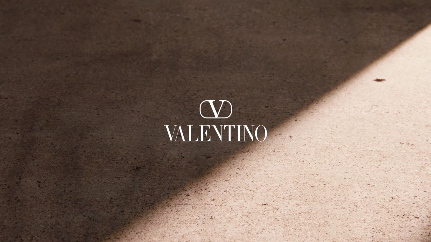 Valentino brand logo on a textured surface with light and shadow. Fashion branding and design element showcase.