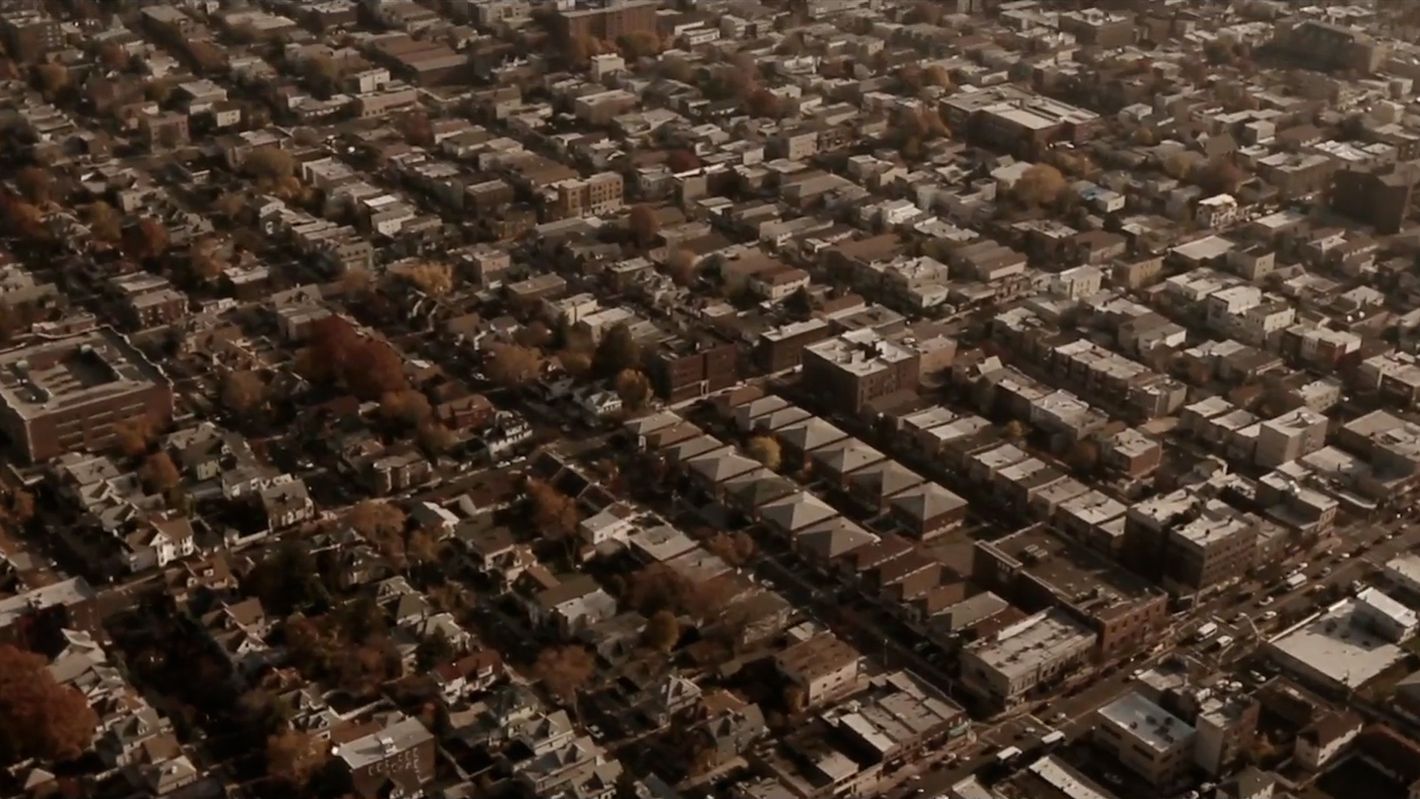 Aerial view of a densely populated urban area featuring buildings and trees, showcasing residential and commercial structures.
