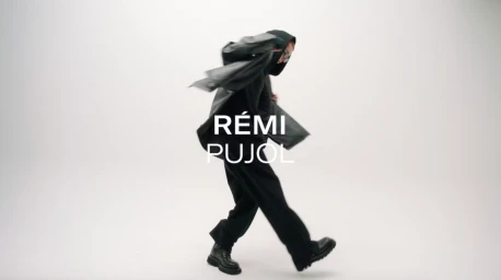 Person in a dark hooded jacket and trousers captured mid-motion against a plain white background.