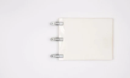 White paper pad secured by three metallic binder clips against a plain white background