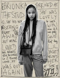 Portrait of a woman wearing a hoodie and carrying a black handbag against a background covered in handwritten text.