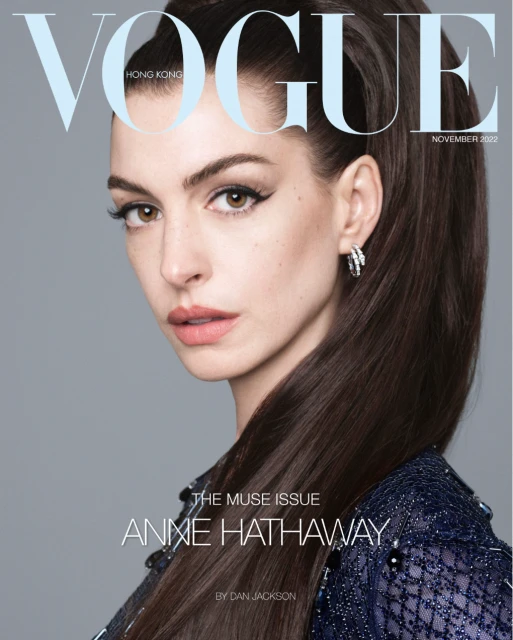 Vogue Hong Kong magazine cover featuring Anne Hathaway with dark hair pulled back, wearing jewelry and a shimmering top against grey.