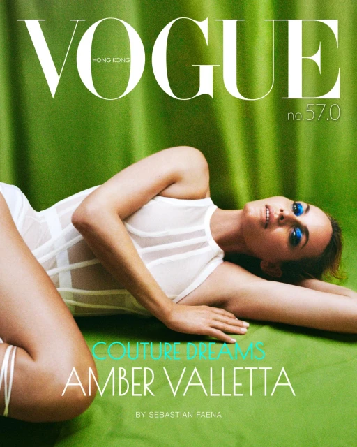 Vogue Hong Kong magazine cover featuring Amber Valletta in a white bodysuit on a green backdrop, editorial shot. Fashion and beauty.
