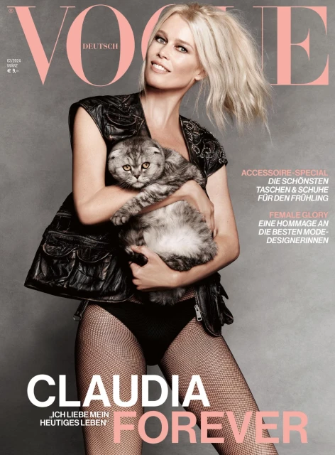 Vogue cover featuring Claudia Schiffer in black outfit holding a grey tabby cat. Magazine cover with fashion and beauty editorial elements.