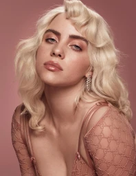 Close-up portrait of Billie Eilish with platinum blonde wavy hair wearing a pink patterned top against a solid pink backdrop