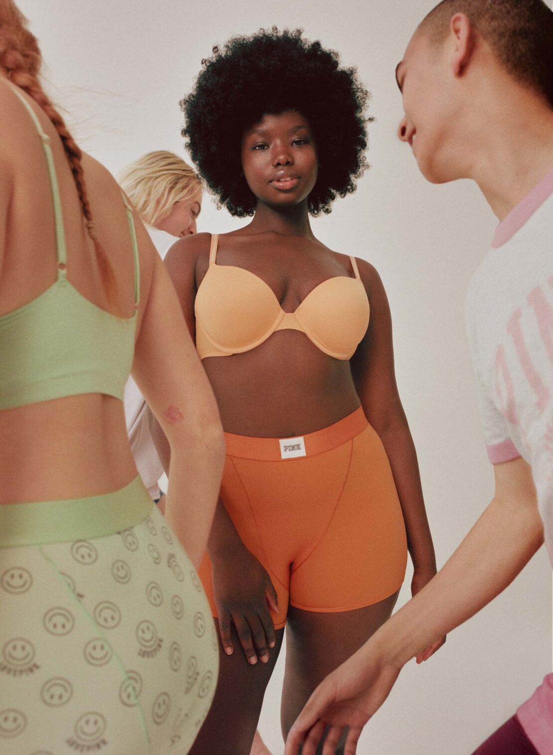 Group of diverse models wearing colorful underwear and casual apparel against a plain white background