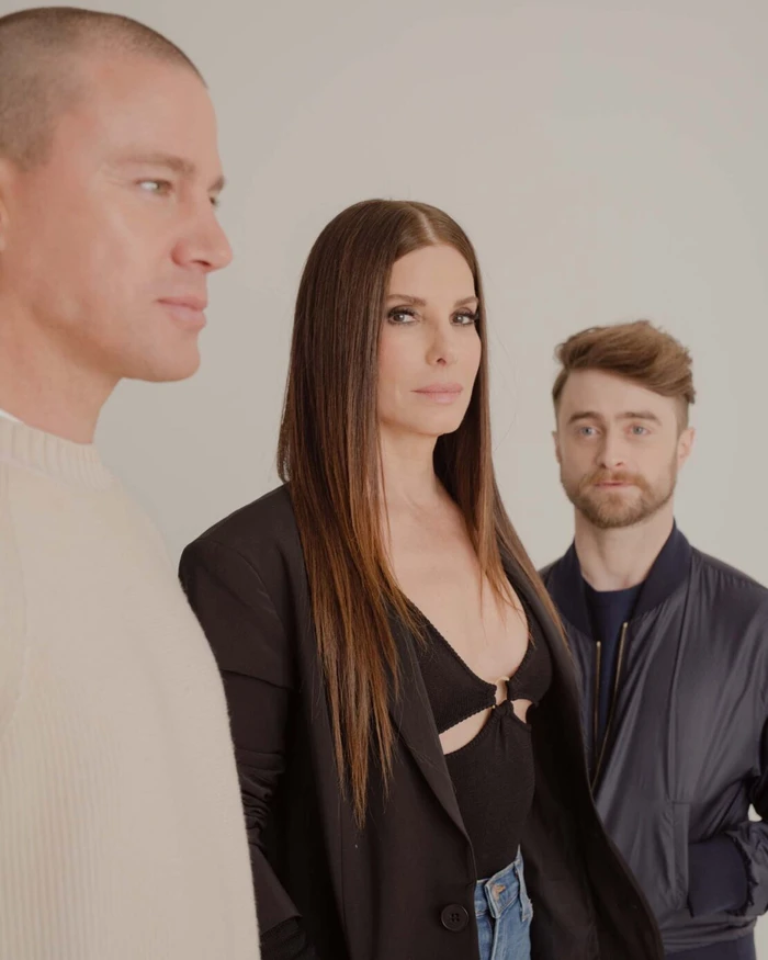 Channing Tatum, Sandra Bullock, and Daniel Radcliffe posing together against a plain white studio background.
