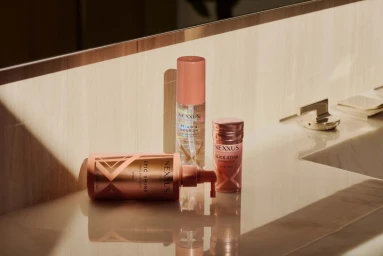 Three Nexxus hair care bottles on a marble vanity under warm diagonal sunlight by photographer Amy Harrity
