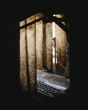 Textured translucent plastic strip curtains hanging in a dark industrial doorway