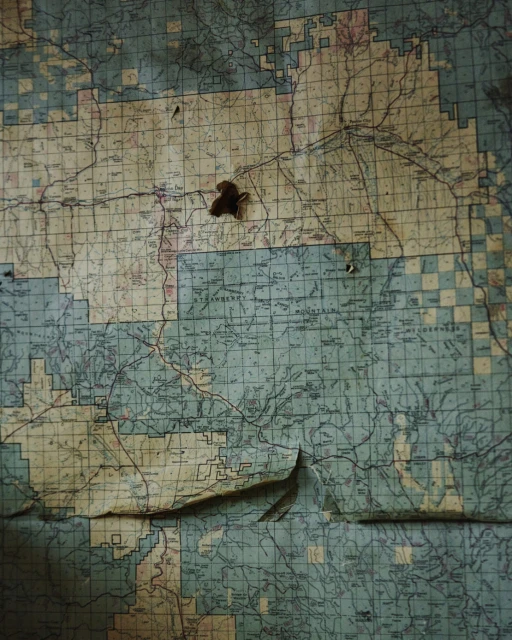 Detailed vintage map featuring geographical outlines, route markings, and a weathered texture with visible wear and tear.