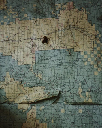 Detailed vintage map featuring geographical outlines, route markings, and a weathered texture with visible wear and tear.