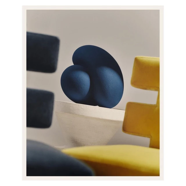 Modern geometric art still life with blue sculptural forms and chairs in yellow and navy creates a visually striking furniture-inspired display.