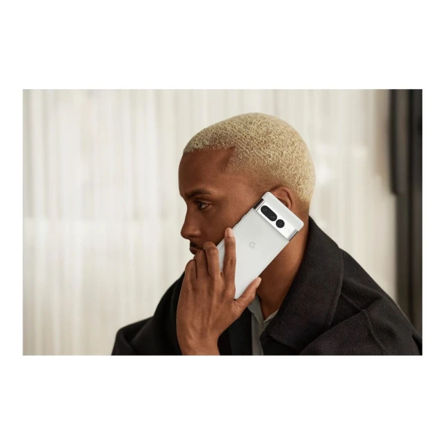 Adult male with short blond hair using a white Google Pixel smartphone. Focus on the device and the person in a neutral setting.