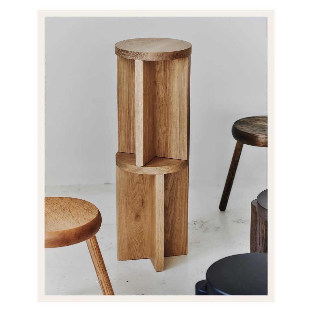 Stacked wooden tables create a modern interior design element, showcasing craftsmanship and light wood tones against a neutral background.