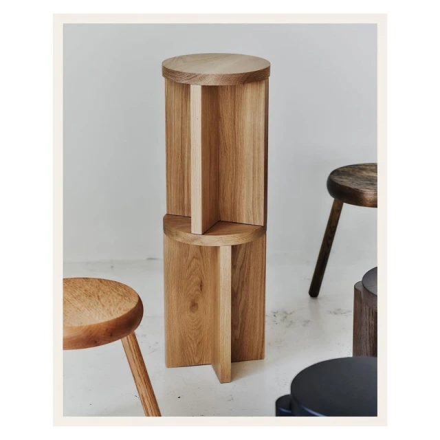 Stacked wooden tables create a modern interior design element, showcasing craftsmanship and light wood tones against a neutral background.
