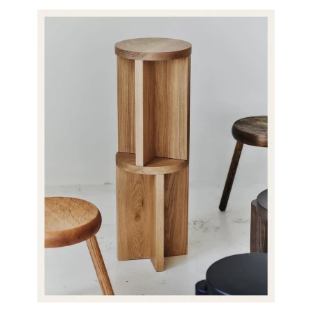 Stacked wooden tables create a modern interior design element, showcasing craftsmanship and light wood tones against a neutral background.