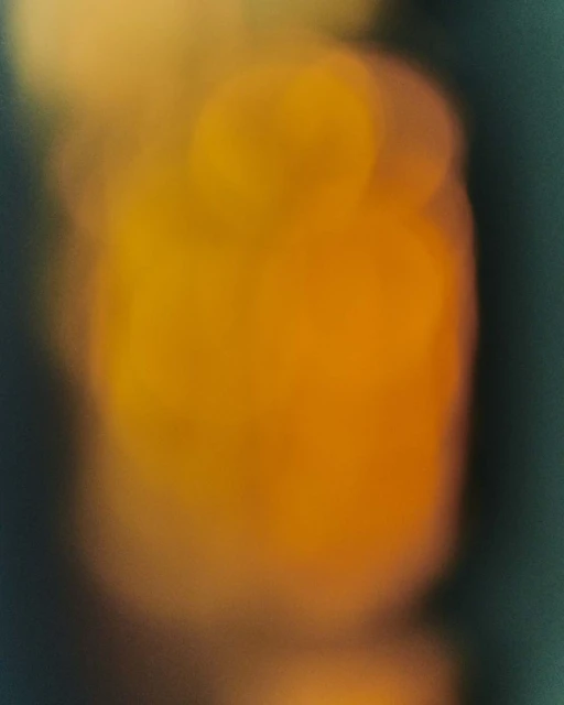 Abstract soft focus photography in shades of orange, yellow, and teal. Blurred effect creates a dreamy, atmospheric visual.