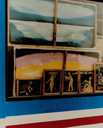 Framed artworks displayed in a window including landscape and figure paintings by Daniel Benson in London