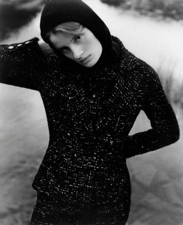 Monochrome portrait of a woman wearing a black tweed jacket and a dark hooded top by Daniel Benson.