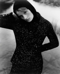 Monochrome portrait of a woman wearing a black tweed jacket and a dark hooded top by Daniel Benson.