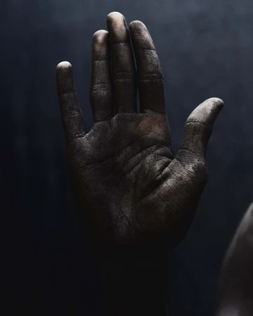 Close-up studio shot of a dirty adult hand, fingers extended against a dark background, showcasing texture and detail with chiaroscuro lighting.