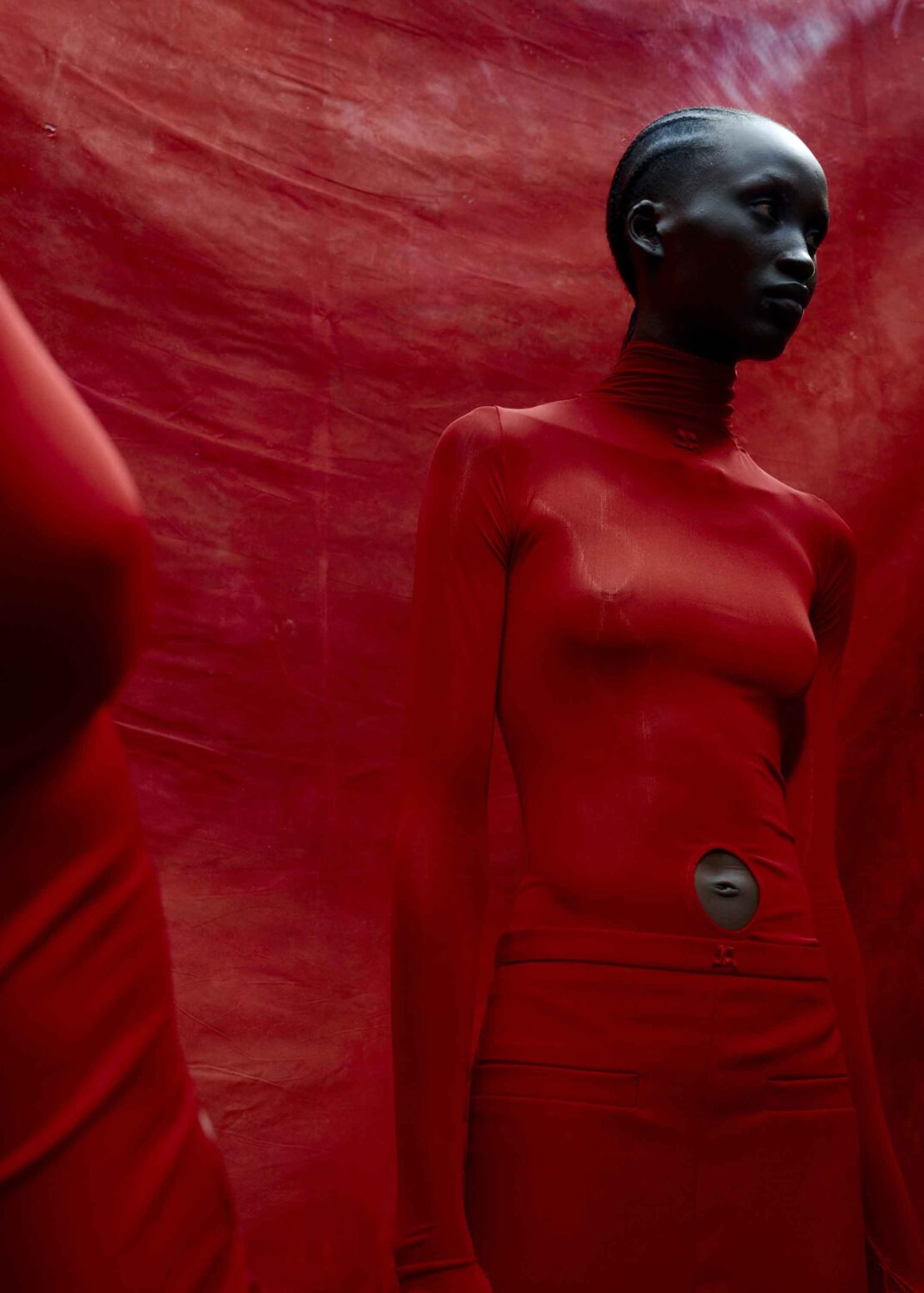 Black woman wearing a red turtleneck top against a textured red background captured by photographer Ekua King in London.