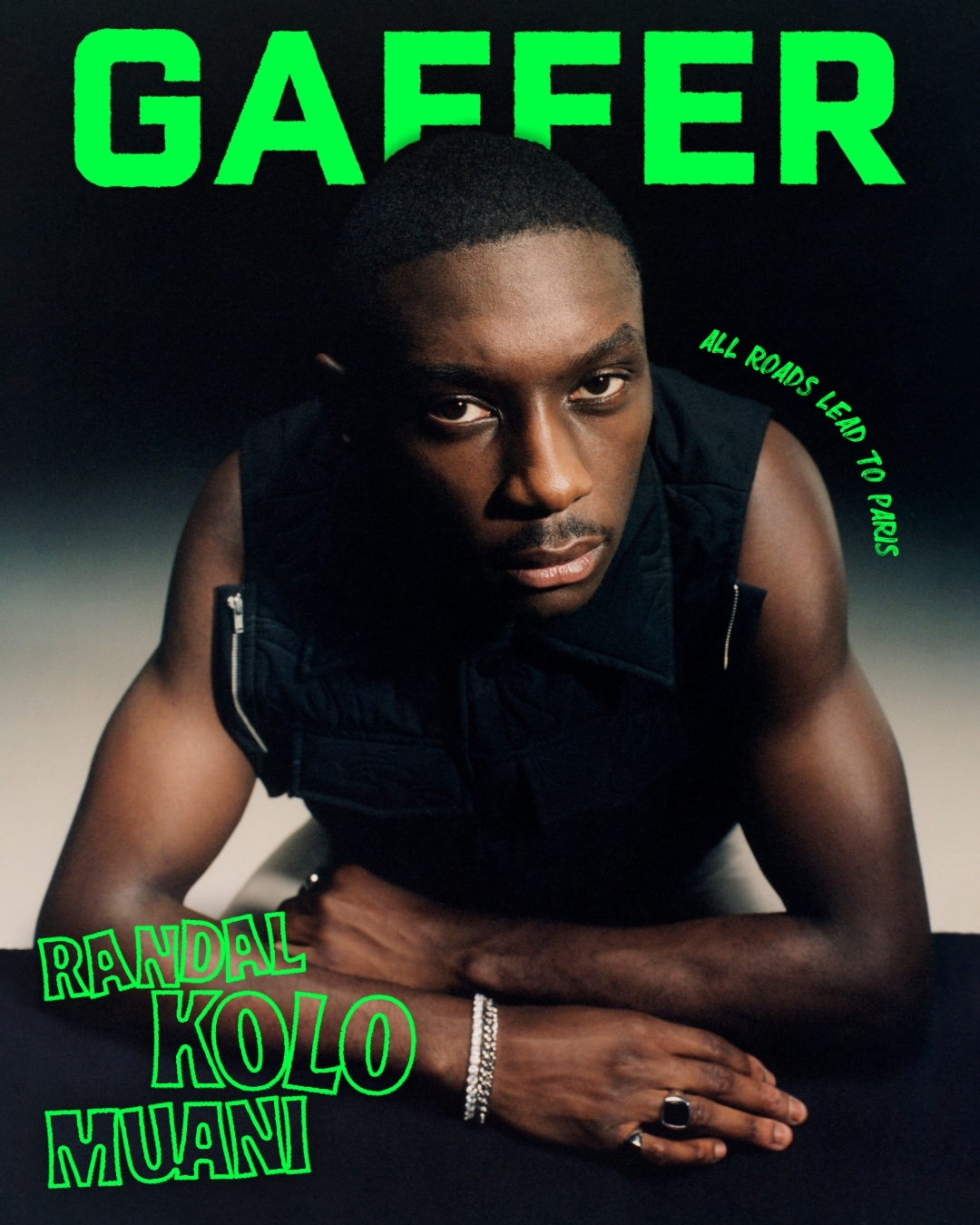 Magazine cover featuring Randal Kolo Muani, dark hair, wearing a black vest and bracelets, posing against a dark background.