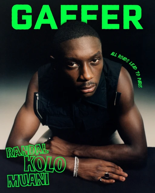 Magazine cover featuring Randal Kolo Muani, dark hair, wearing a black vest and bracelets, posing against a dark background.