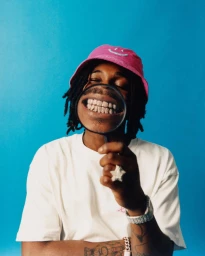 Portrait of a Black man wearing a pink bucket hat and white t-shirt holding a magnifying glass in front of his smiling mouth by Elliott Wilcox