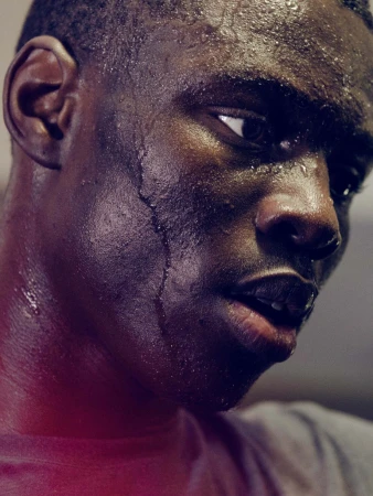 Close-up portrait of a sweating Black man with water droplets running down his face captured by Emily Maye