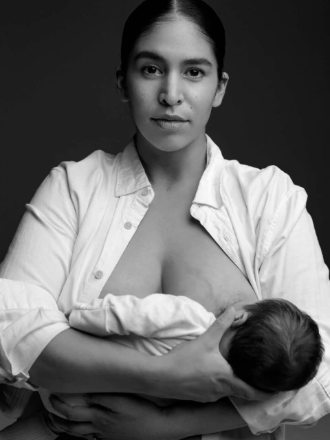 Black and white portrait of a mother breastfeeding her baby, showcasing a close-up view of a breastfeeding mother and child.