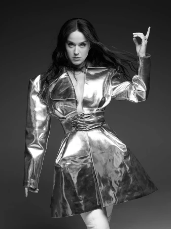 Black and white portrait of an adult woman wearing a shiny, futuristic-looking jacket, standing in front of a dark background.