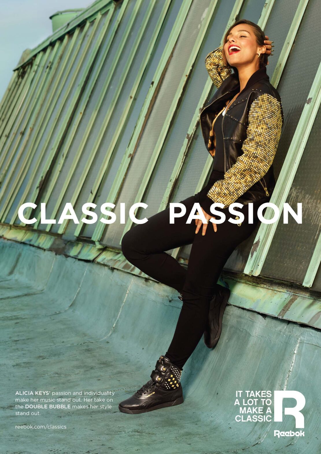 Alicia Keys poses wearing Reebok sneakers and a jacket with tweed sleeves, set against an urban rooftop on a sunny day.
